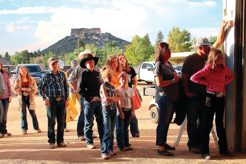 A group of onlookers watch the Douglas County livestock sale from outside the venue Friday, July 31.