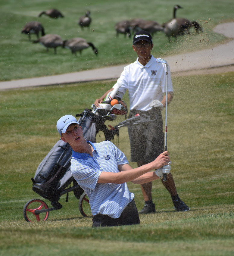 Ralston Valley junior Gage Messingham blasts his way out of a bunker as Arvada West sophomore Yusuke Ogi looks on during the second Jeffco League boys golf tournament of the season Monday, Aug. 17, at Raccoon Creek Golf Course in Littleton.