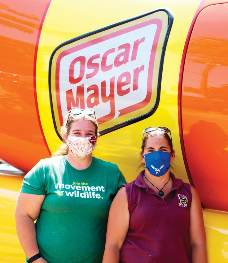 Zookeepers Jordan Baur and Christina Seely take a quick break from their duties to get their picture taken with the Oscar Mayer Wienermobile during its visit to the Denver Zoo on Aug. 19.