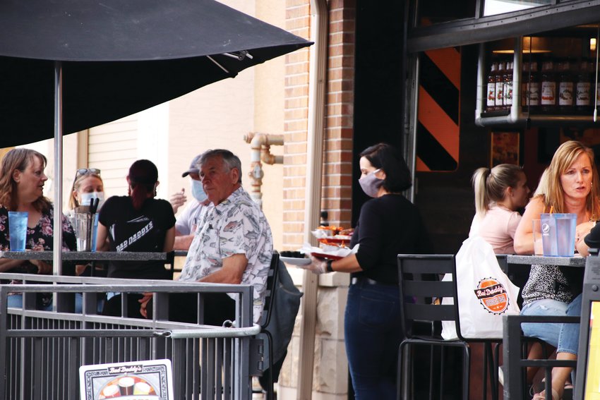 A crowd sits outside Bad Daddy's Burger Bar on Oct. 9 at The Streets at SouthGlenn outdoor mall. Dozens of patrons throughout the shopping center gathered at outdoor seating at restaurants that have adjusted to the pandemic.