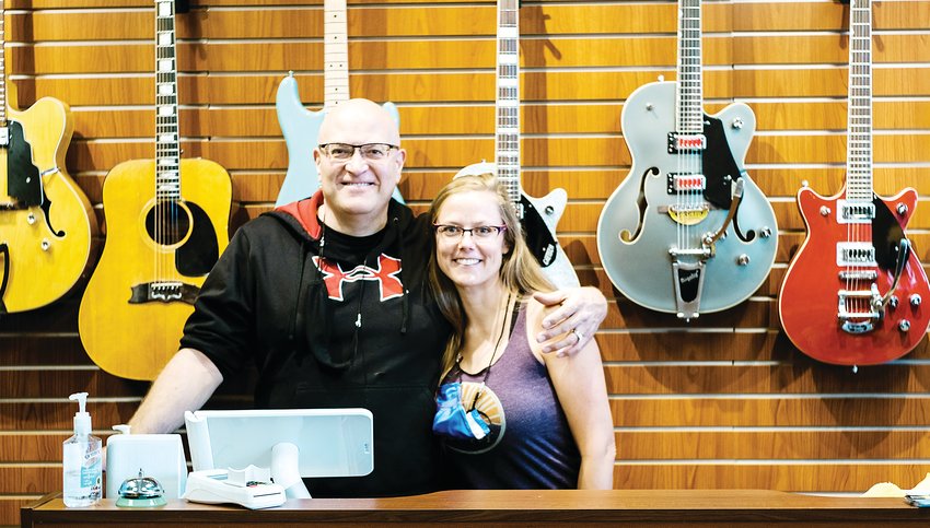 Chris Thomas and his daughter behind the counter at Spaceman Guitars in Lakewood.