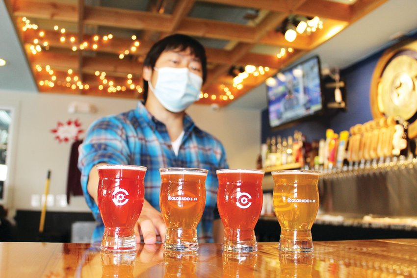 Luke Furey, operations manager at Golden's Colorado + 49 Cidery & Pub, assembles a flight of ciders. The drink, typically made from fermented apples, features a spectrum of dryness to sweetness as well as a variety of flavors. Furey said one of the cidery's most popular ones is a Nordic dry blueberry lavender cider.