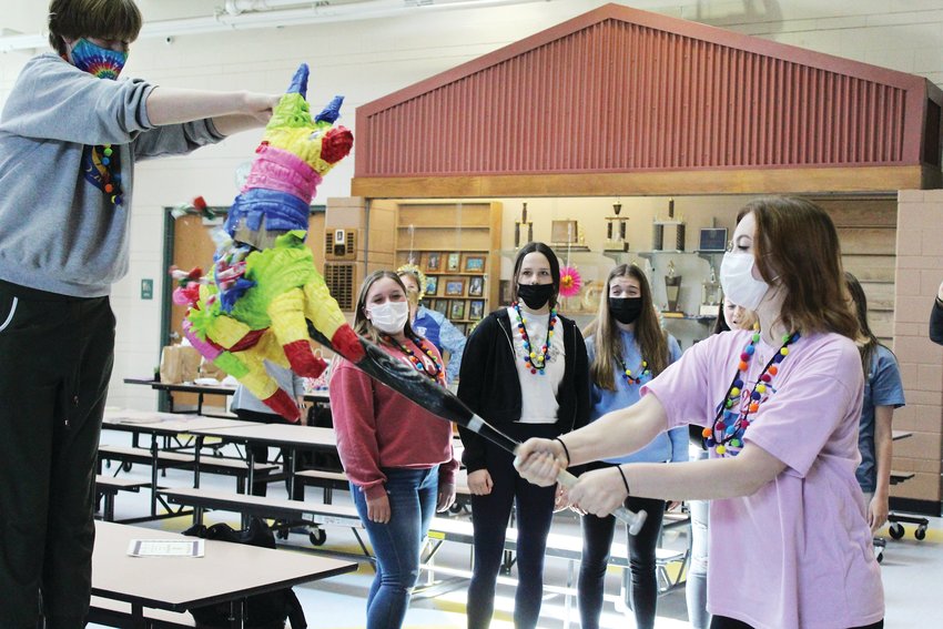 Junior Synneva Wippler, right, breaks the pinata held by sophomore Skylah Inman during the volleyball program's Cinco de Mayo-themed banquet on May 5.