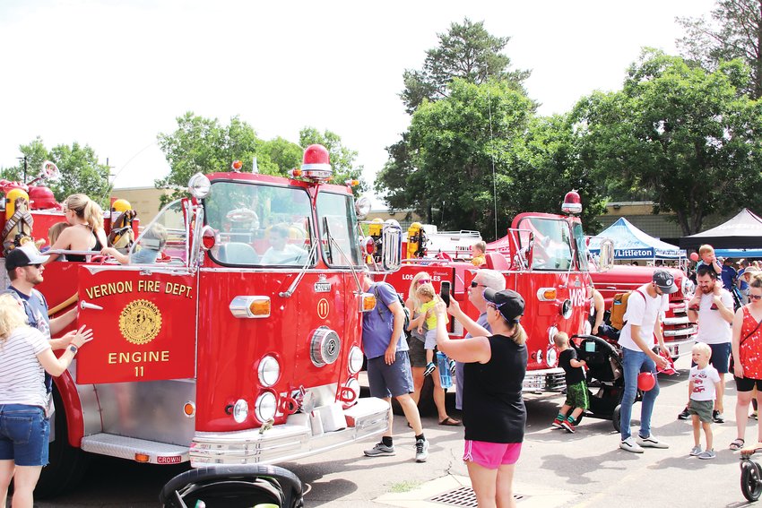 Youngsters clamber over vintage fire trucks.