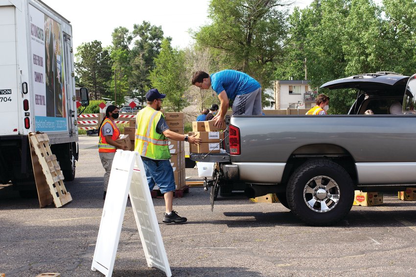 Workers pitch in to load food for distribution to Jeffco Schools’ summer programs