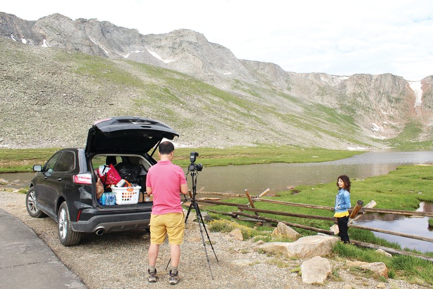 Eugene Sheng and Yen Zhang from Chicago take photos on July 22 at Summit Lake below Mount Evans. The two made reservations online about a week beforehand, which Zhang said was relatively easy.