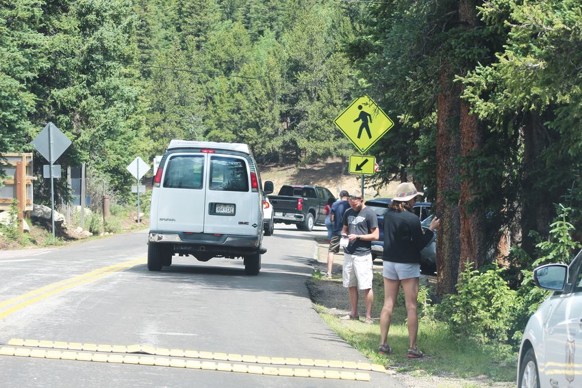 Visitors stand near the Mount Evans Scenic Byway welcome station to purchase reservations before ascending the mountain on July 22. While the U.S. Forest Service does have wireless internet at the welcome station to accommodate visitors who didn't know about the reservation system before arriving, the agency stresses that this situation can and should be avoided by making reservations online well in advance.