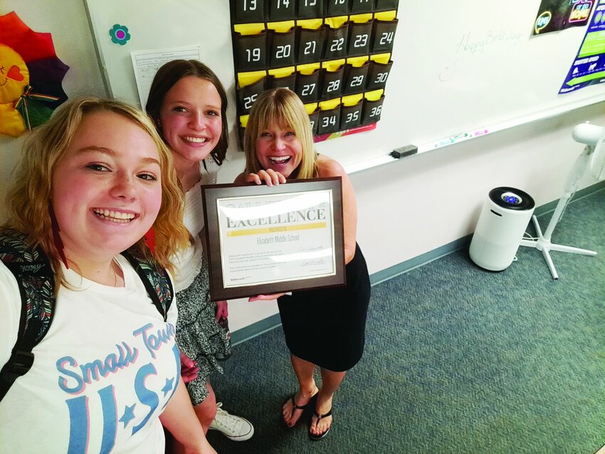 Teacher Lisa Mullins and two students from Elizabeth Middle School pose with a yearbook award won in 2022.