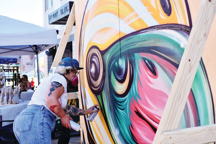 Kaitlin Ziesmer paints a mural as part of the Shindig’s mural competition — where artists competed for the chance to create a mural in Olde Town.