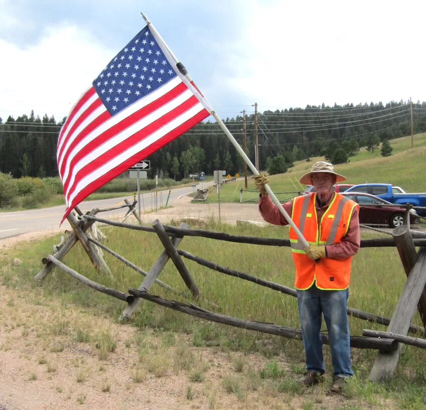 Army veteran Neil Whitehead III waved an American flag at the corner of Highway 73 and Shadow Mountain Drive to honor Major Toby Lewis, who died when his aircraft crashed on Melville Island north of Darwin, Australia.