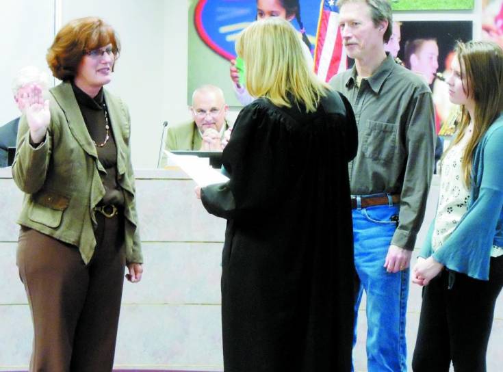 From left, incoming school board member Judi Reynolds is sworn in Dec. 5 by Judge Susanna Meissner-Cutler while board president Kevin Larsen, center, and Reyold's husband Scott and daughter Addi watch. Photo by Jane Reuter