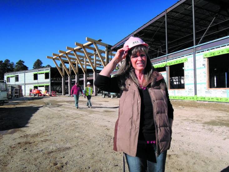 Elbert School District business manager Bev McGuire dons a hard hat Dec. 17 at the construction site of the new $20.6 million Elbert school. McGuire said the project remains on track to open in the fall of 2014.