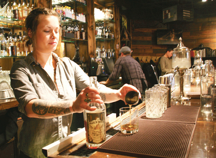 Carly Raemer, assistant manager and bartender at the Golden Moon Speakeasy, located on Miner’s Alley in Golden, pours a glass of the Golden Moon Colorado Single Malt Whiskey.