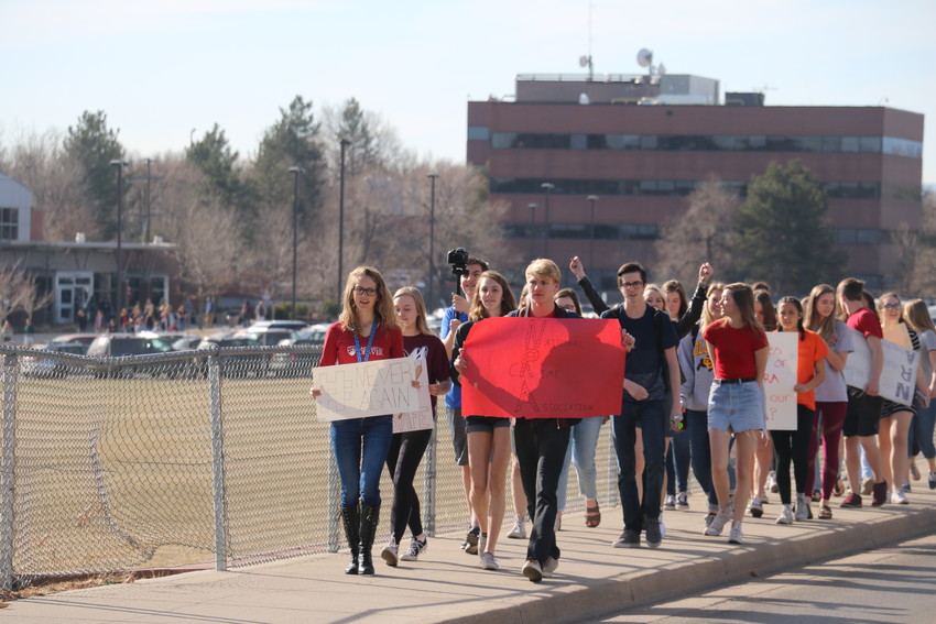 A stream of several hundred students leave Lakewood High School to stand along Kipling Street on March 14. The walk-out was one of many in the metro area to honor victims of gun violence.