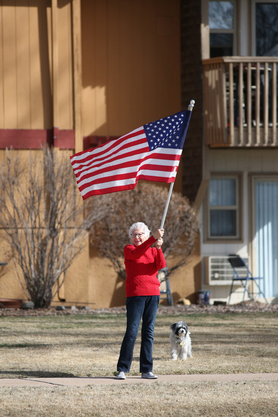 Betty Campbell, 85, waves the American Flag across the street from where Arvada West students stood during their walkout protest. Campbell said she wanted to support the students. “I’m old,” she said. “But that doesn’t mean I don’t want to be there next to the kids.”