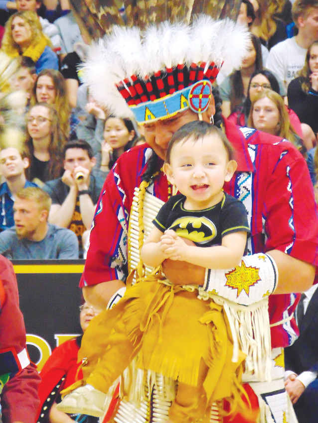 Annin Soldier Wolf holds his son Roger, 1, while the two dance in Arapahoe High School's gym.