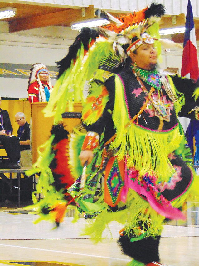 Dean Littleshield dances in a traditional ceremonial costume while tribal elder Darrell Lone Bear, left, looks on.