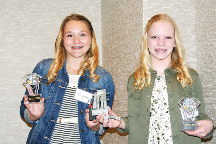 Maddie Rice, left, and Sophia Eakes, both middle schoolers at Bell Middle School in Golden, hold up their awards and bionic hand on International Women’s Day, March 8, 2017, after winning first place in the Jefferson County Public Library’s Girls in STEM Competition.