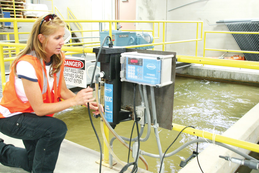Wendy Weiman, the project engineer for North Table Mountain Water and Sanitation District, checks the water clarity at the organization’s water treatment plant near Highway 93 and West 64th Parkway in Golden.