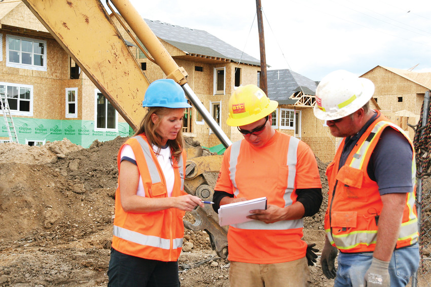 Wendy Weiman, left, the project engineer for North Table Mountain Water and Sanitation District, talks with, from left, laborer Olu Villalobos and foreman Fredy Peraza on a project where the crew was putting in pipe casing for a new development at McIntire Place in Golden.
