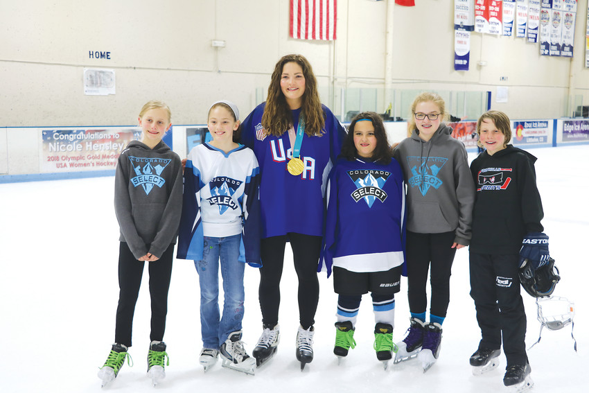 Nicole Hensley, a goalie who won gold at this year's Olympics, poses with goalies from the local Foothill Fliers and Colorado Select hockey teams at Littleton's Edge Ice Arena on April 15.