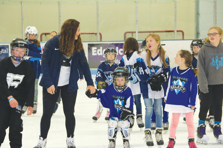 Gold-medal winner Nicole Hensley skates with Foothills Fliers and Colorado Select players on April 15 at the Edge Ice Arena.
