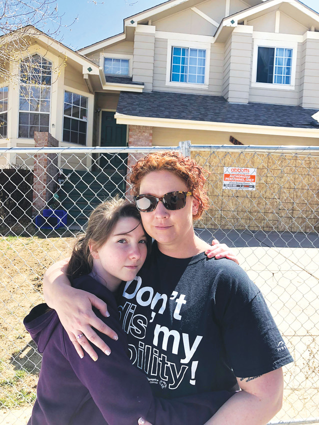 Lisa Bunch and her daughter, Sierra-Kay Okimoto, stand before their home damaged in a Castle Rock fire that destroyed two houses and impacted five others.