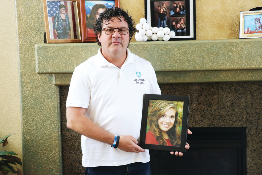 Standing in his Parker home, Johnnie Medina holds a photo of his daughter, Mikayla, who was 24 years old when she died by suicide nearly a year ago. “You don’t really move forward,” he said. “You just exist.”