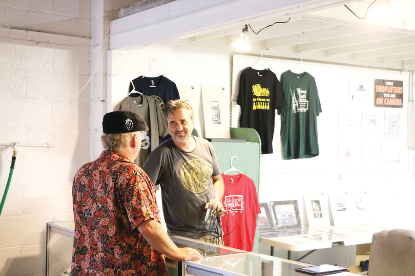 The Colfax Museum founder Jonny Barber, right, visits with a guest at his temporary pawn shop and pop-up Colfax Museum on July 6. The event was part of an effort to give residents a taste of what to expect and raise awareness about the work Barber is doing.