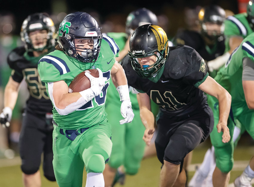 ThunderRidge's Spencer Lambert rumbles for some of his 173 yards on the ground as he's chased by Mountain Vista's Christopher Perella (41).  Lambert's Grizzlies cruised to a 49-10 victory at Shea Stadium on Sept. 28.