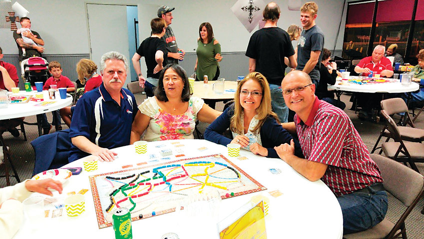 Seated at the table from left, Tom and June Schichtel and Rob and Wendy Semin, try out some board games during the September 2016 Friends and Family Game Night, hosted by Jo Ellen and Kevin Christian of Centennial. The Christians will be opening their new business, Game Train, in Highlands Ranch in December.