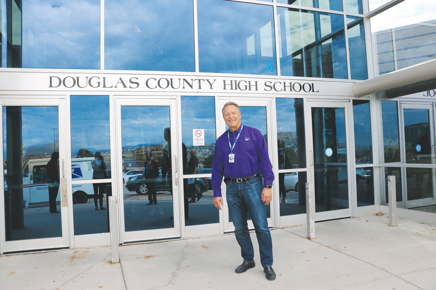 Douglas County High School Principal Tony Kappas stands in front of his school in Castle Rock. One of DCSD's oldest, the school has a long list of Tier 1 needs, which are critical building repairs that risk safety.
