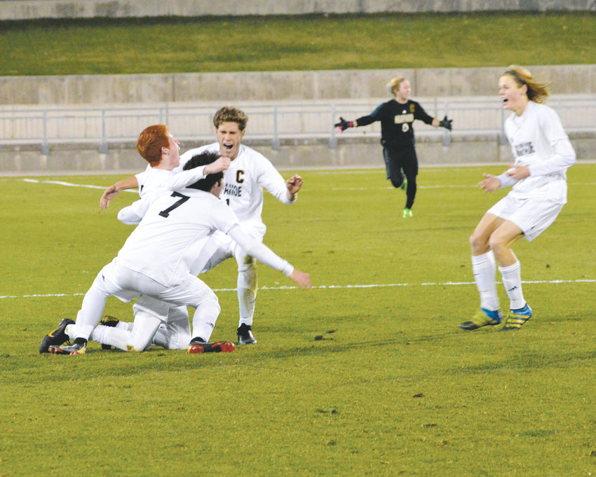 Arapahoe players celebrate after a 2-1 win over Grandview on Nov. 9 gave the school its sixth boys soccer championship but the first one since 1997. The Warriors finished the season with a 17-1-2 record.