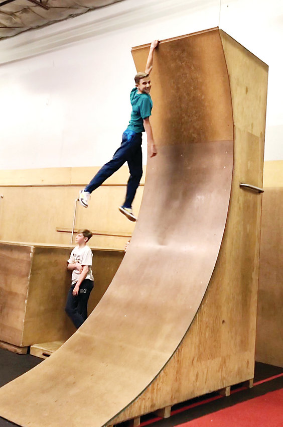 Ayden Perkins, 14, scales Path Movement’s warped wall, a replica from the popular television show “American Ninja Warrior.” Perkins has been training at Path Movement in Littleton for around four years.