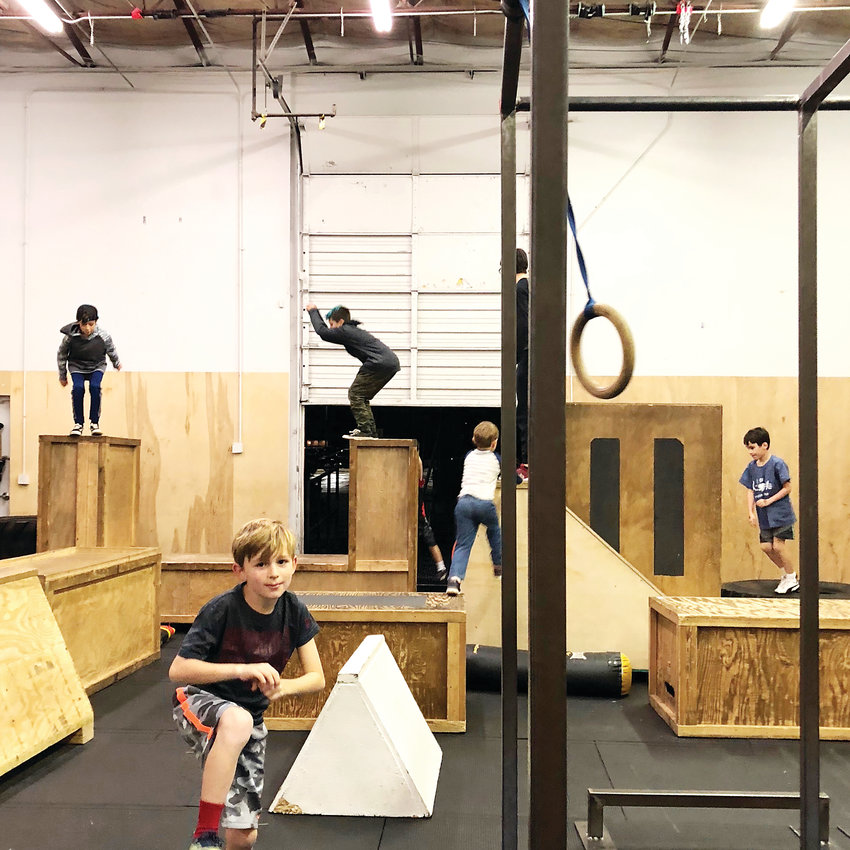 Students practice their parkour skills during a class at Path Movement. Like many parkour gyms, the Littleton operation consists of a mixture between classes taught by coaches and “open train sessions” in which students have more freedom to choose what to practice.
