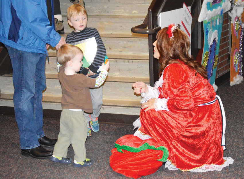 Mayor Carol Dodge, dressed as the Merry Mayor, gives candy to brothers Garrette Cindric, 5, and Declan, 2, at the city's Noel Northglenn celebration Dec. 7.