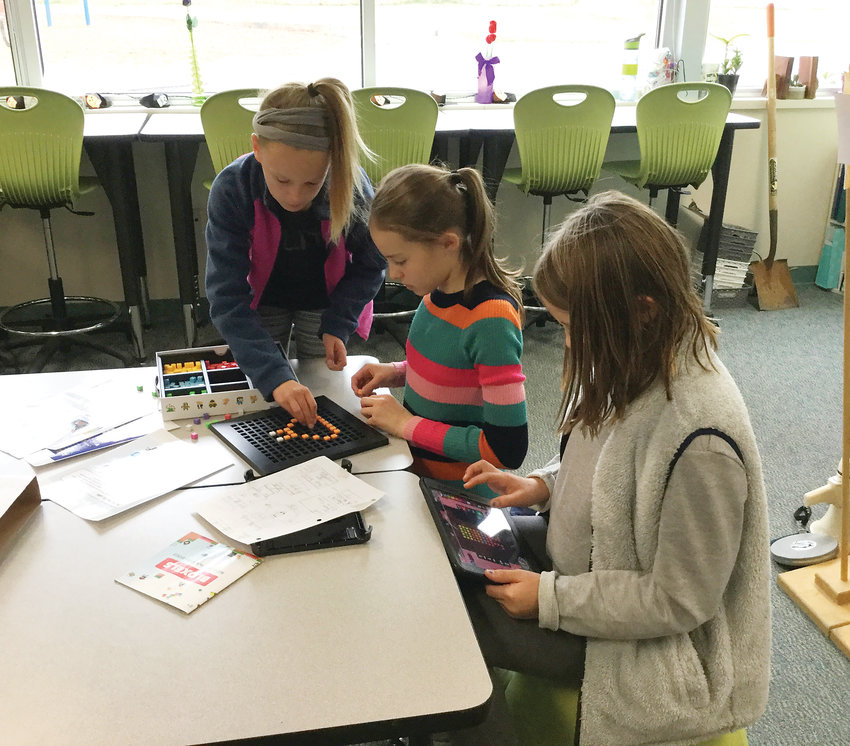 Three Fairmount Elementary School fifth graders, from left clockwise, Hadley Nauslar, Sally Kohara and Kaasen Pass, on Oct. 9, 2018, use the Bloxels platform to design and code a digital game for their younger study buddies to play to learn about being safe and smart on the internet.