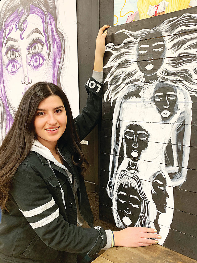 Darryah M. AlSaaid, Littleton High art student with her painting showing many faces-turned in various directions. She is focused on identity and what makes up a person.