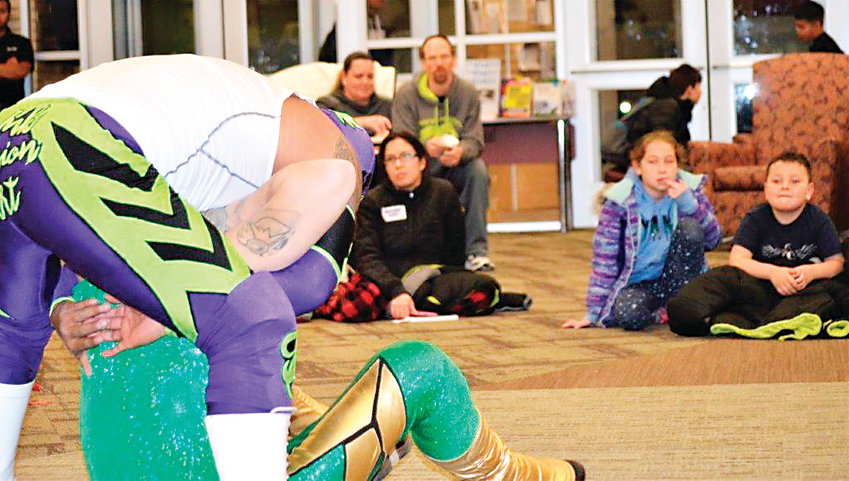 Anythink Library York St. patrons watch as luchadores Heros and Sol Azteca trade moves Feb. 26.