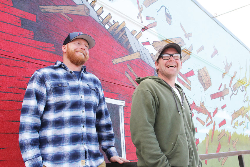 Jason Sakry, left, and Dagan Thomas stand March 7 in front of the mural on the side of Barnhouse Tap, a bar at 4361 S. Broadway in Englewood. The bar, which opened in December, hopes to establish itself as a go-to place for the surrounding neighborhood.