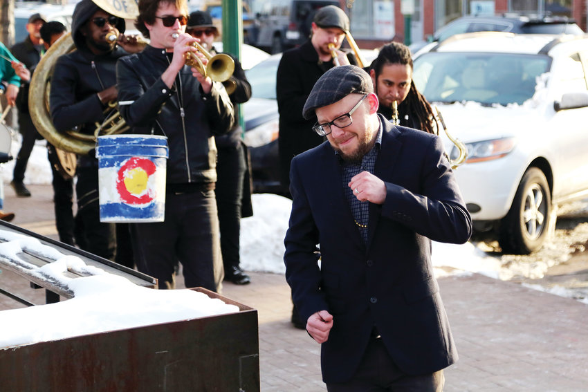 Joseph Hengstler, executive director of the Arvada Business Improvement District, leads the brass band into Denver Beer Co. to end the Fat Tuesday parade.