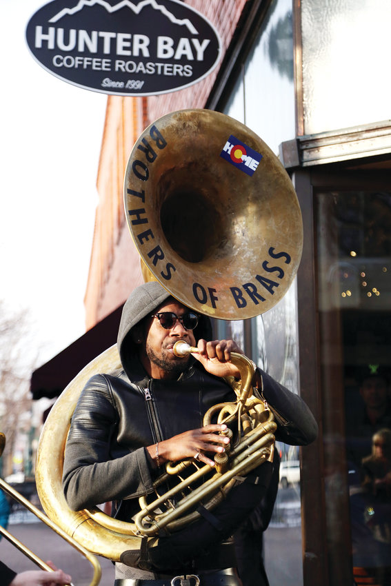 Khalil Simon plays tuba with the Brothers of Brass band while walking the streets of Olde Town Arvada.