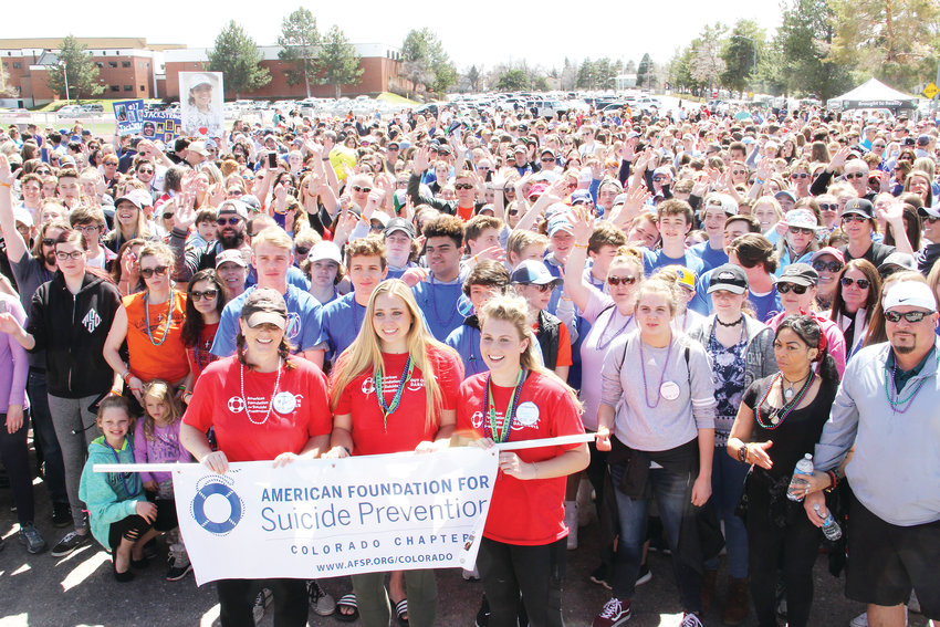 Several hundred stand behind the organizers of the Out of the Darkness suicide-prevention walk April 14 on the Arapahoe High School campus. In front, left to right, stand Melissa Hughes, a volunteer with the American Foundation for Suicide Prevention, and Brooke Smiley and Ry Renshaw, Arapahoe students.