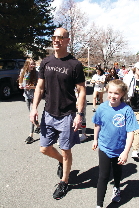 Jim Hansen, 50, and Samantha Stearns, 10, keep a brisk pace April 14 during a suicide-prevention walk in the neighborhood near Arapahoe High School. Many parents from the community like Hansen, who lives in Centennial, participated in the walk.