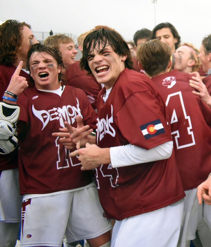 Golden seniors Brady desGarennes, left, and Garrett Landmark celebrate after the Demons won the Class 4A boys lacrosse state championship over defending state champion Cheyenne Mountain on Monday, May 20, at All-City Stadium.