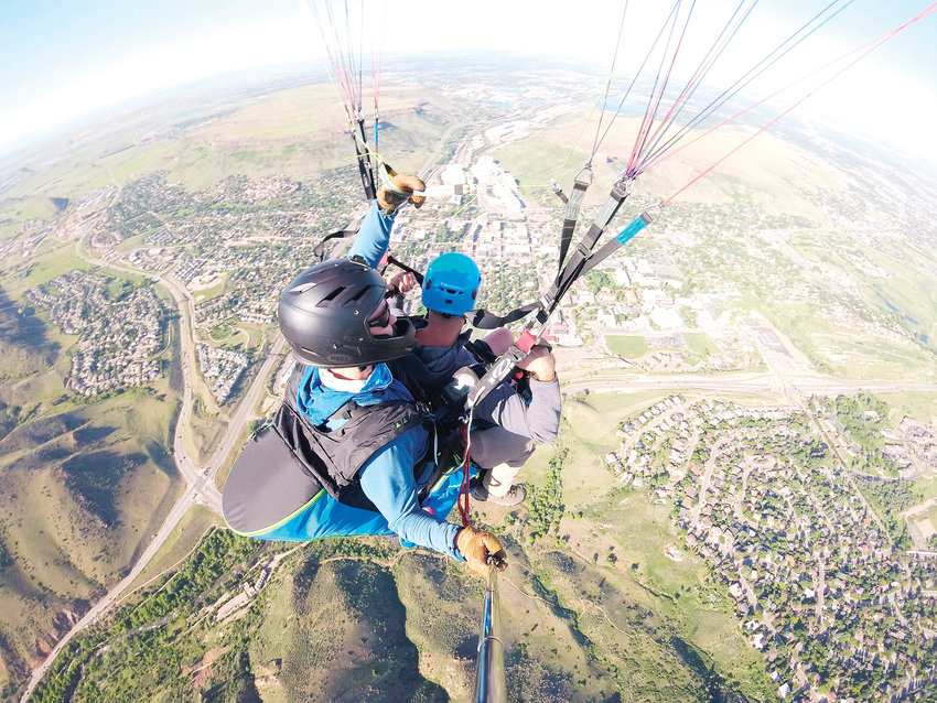A GoPro captures a picture of David Hach, in the back, co-owner of Paraglide Tandem, as he and a passenger soar over Golden on a recent flight. Some people go tandem paragliding to cross something off a bucket list and some do it to get over a fear of heights, Hach said, but a flight also tends to be a popular birthday gift.