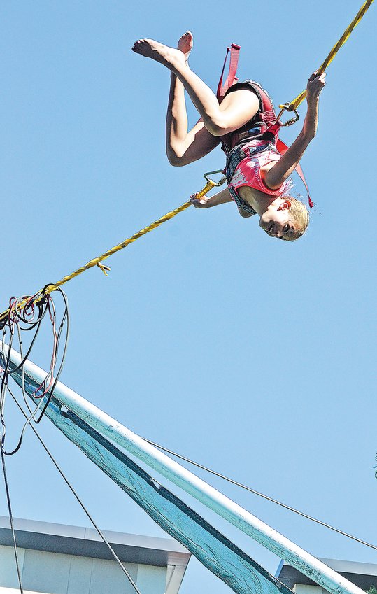 Aubrielle Wenzel, 9, of Arvada, does a flip while on a bungee ride at the Arvada Harvest Festival in 2016.