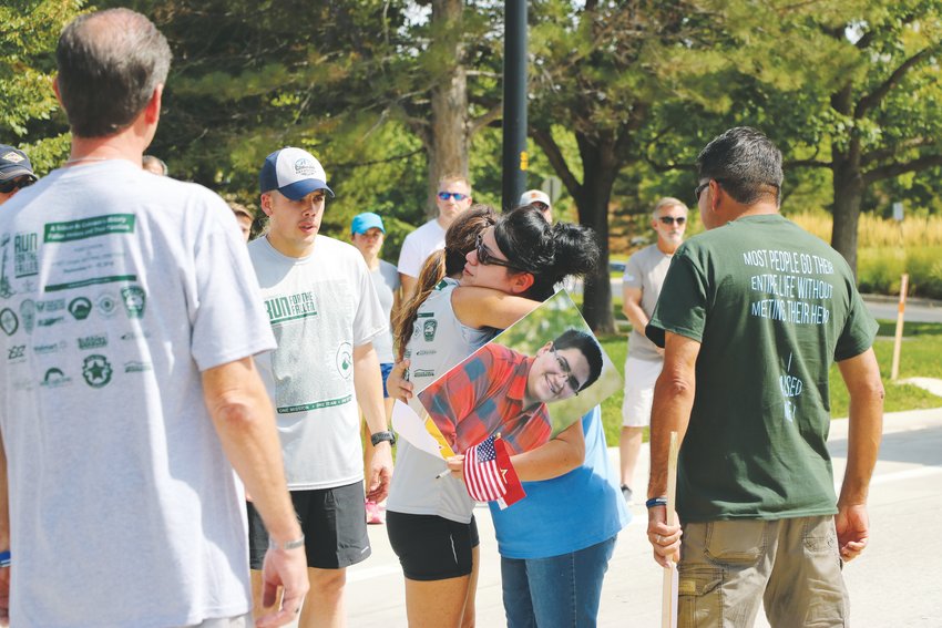 Maria Castillo hugs a runner from the Run From the Fallen organization after her son, Kendrick Castillo is honored. Kendrick was recognized along with other Colorado heroes during the 100-mile tribute.