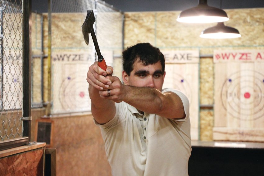 Jordan Scheremeta takes a slow-motion practice swing at Wyze Axe, an ax-throwing business in Englewood. Scheremeta nailed a few bullseyes during his first-ever round of ax throwing.