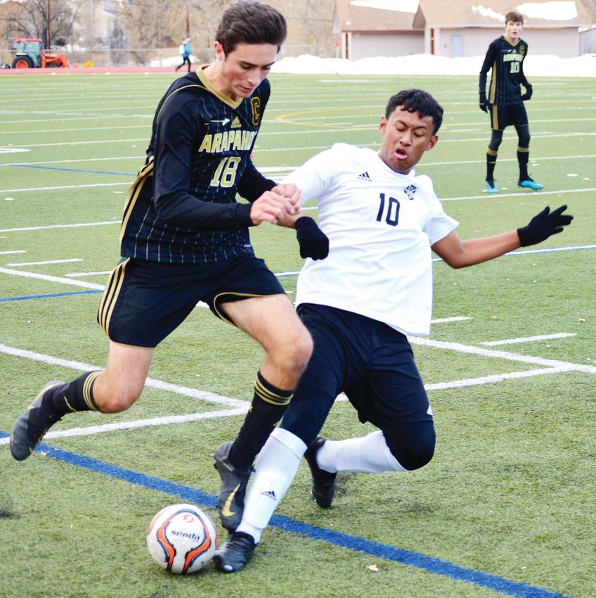 Arapahoe senior Garrett Lyles (18) attempts to get to the ball despite the efforts of Rangeview's Christian Valdez (10) during the first round boys soccer state playoff game on Nov. 1 at Littleton Public Schools Stadium. Arapahoe won 2-1 in overtime on a goal by Sam Myers.